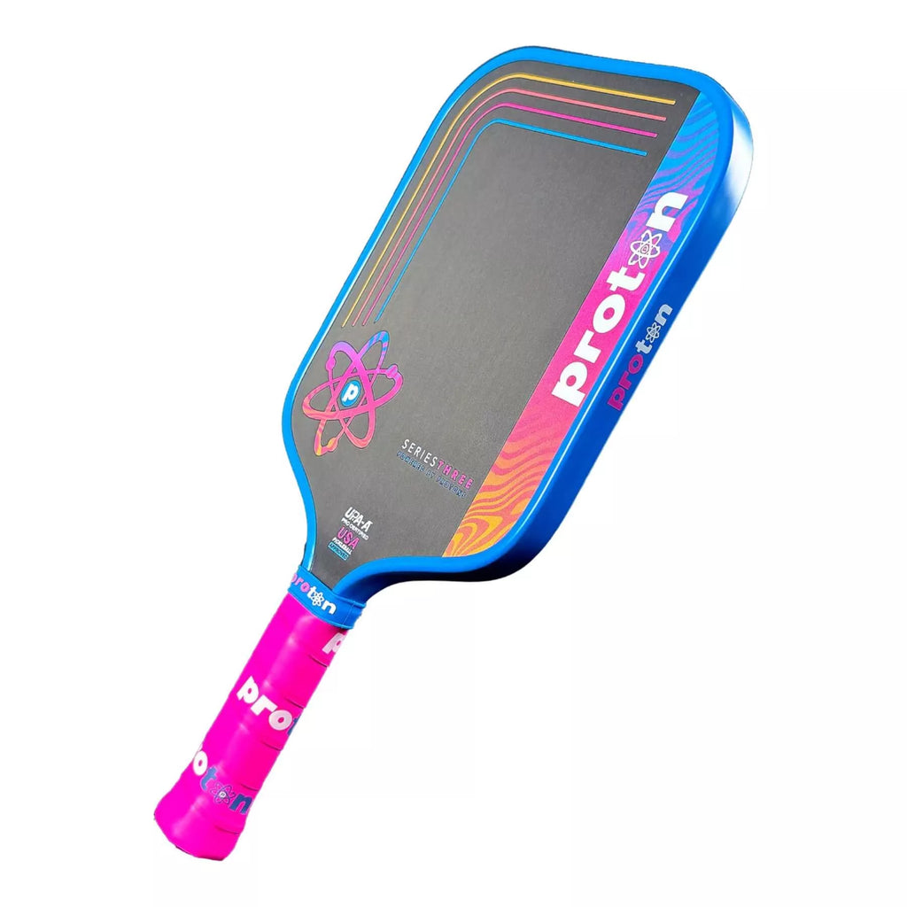A Proton Series Three - Project Flamingo Widebody (Square) 15 mm Pickleball Paddle with blue edge guard, 
available from IamRacketsports.com, online and in-store, Miami USA, worldwide shipping.