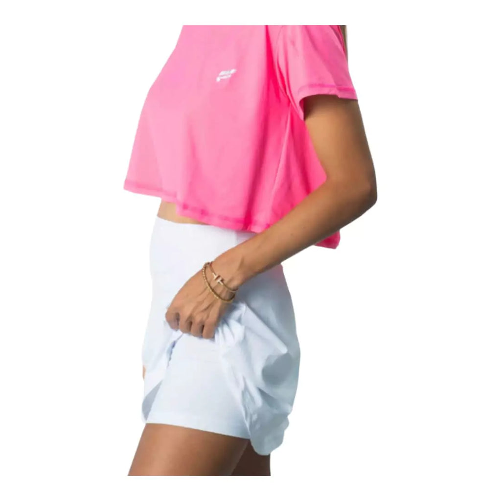 SPORT:BEACH TENNIS. Shop Flow Beach tennis at iamBeachTennis miami shop. Female model, side profile showing  built in shorts of a white  Flow Beach Tennis LAGUNA Beach Tennis Skirt.