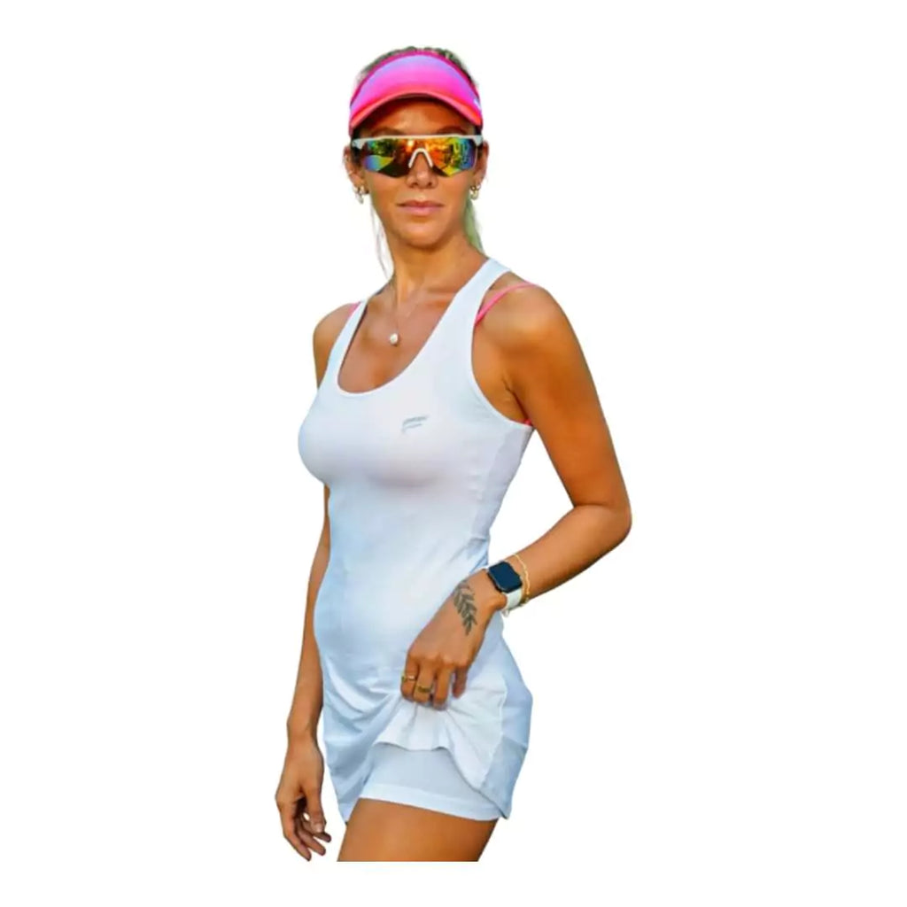 SPORT:BEACH TENNIS. Shop Flow Beach tennis at iamBeachTennis miami shop. Female model, side profile showing  built in shorts of a white  Flow MIAMI Cut Out Back Slim Dress.