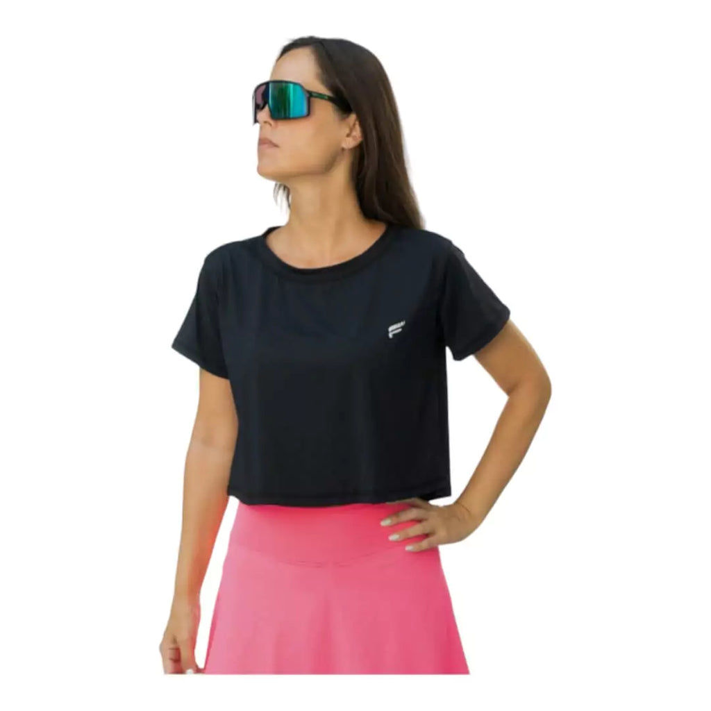 SPORT:BEACH TENNIS. Shop Flow Beach tennis at "iamracketsports.com". Female model, wearing a black Flow VENICE Cropped T-Shirt.