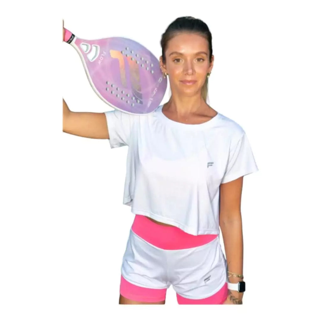 SPORT:BEACH TENNIS. Shop Flow Beach tennis at iamBeachTennis Depot Store. Female model, holding a paddle wearing a white Flow VENICE Cropped T-Shirt.