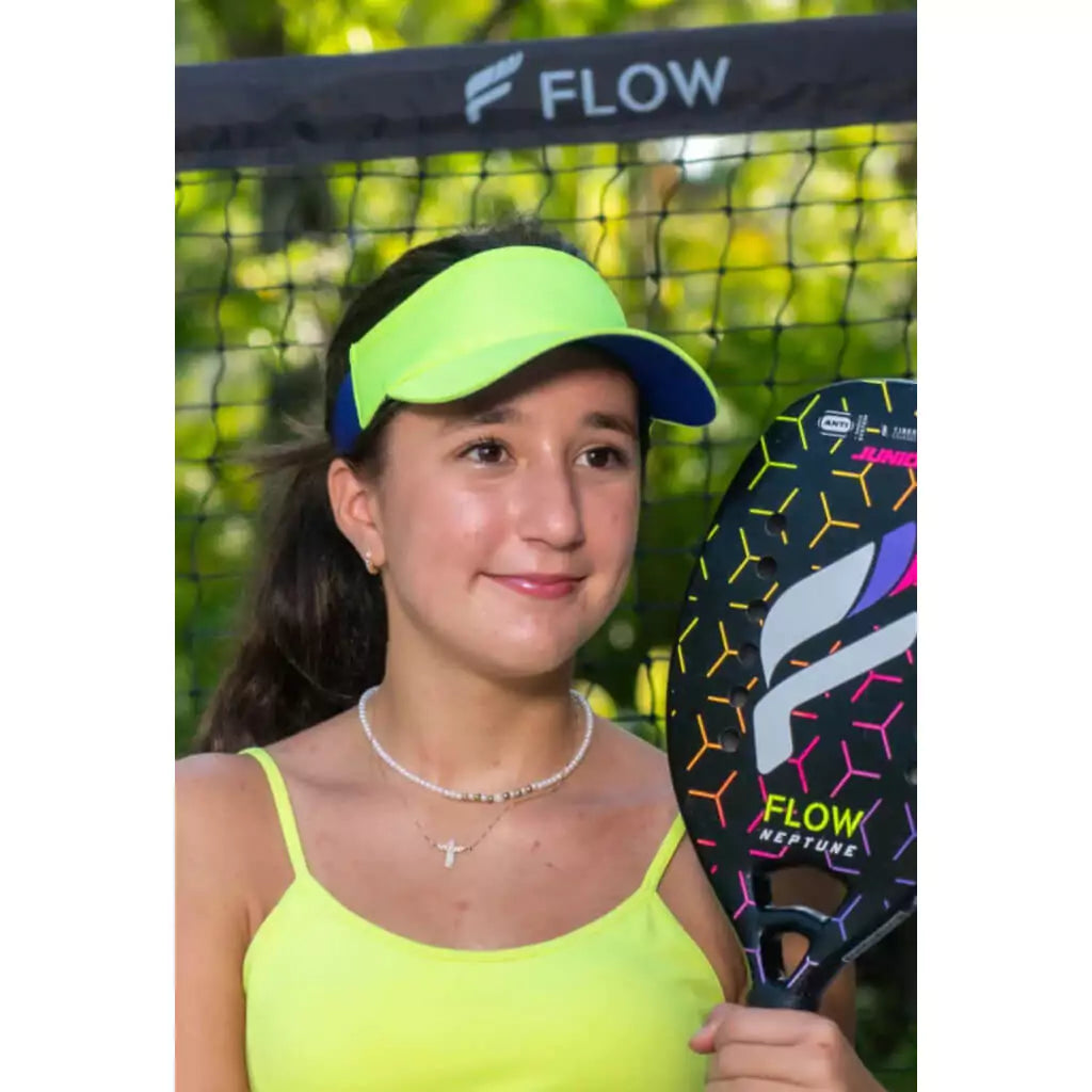 SPORT:BEACH TENNIS. Shop Flow Beach tennis at iamBeachTennis Colisium Store. Junior female player wearing green Flow Beach Tennis Art Visor, standing at court net.