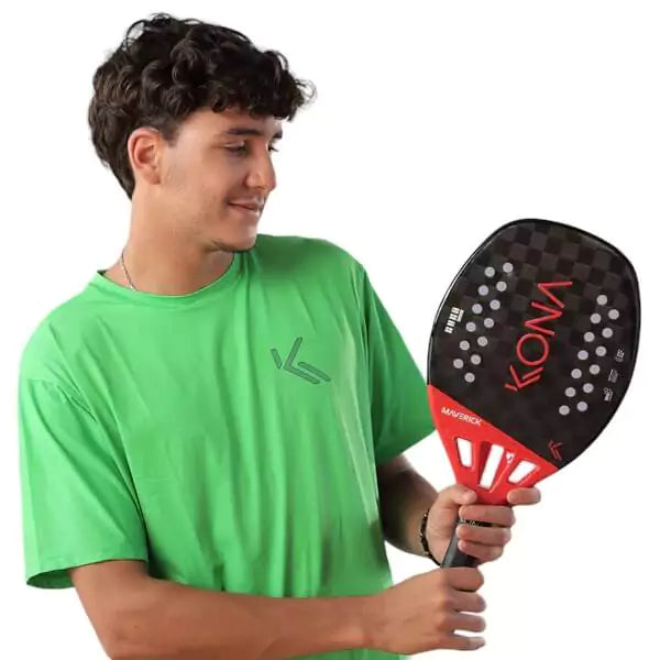 Player holding  a Kona MAVERICK RED 2024 Beach Tennis Paddle. Shop Kona at iamBeachTennis.com.