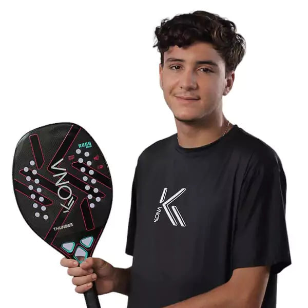 A player holding  a Kona THUNDER BLACK 2024 Beach Tennis Paddle. Shop Kona at i am Beach Tennis store.