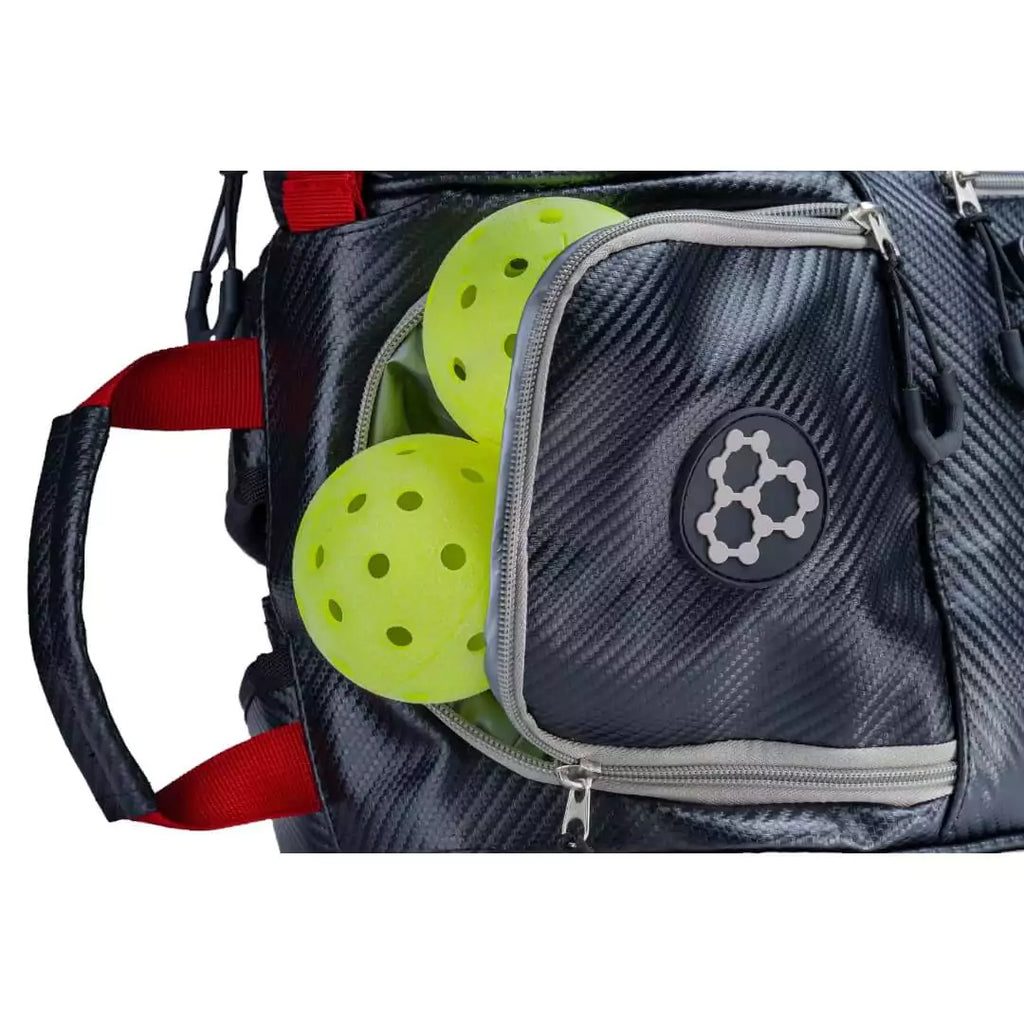 SPORT:PICKLEBALL.  Shop for CRBN bags at iamRacketSports.com. View of front accessories pocket of the  CRBN Pro Team Tour pickleball Bag 2.0.