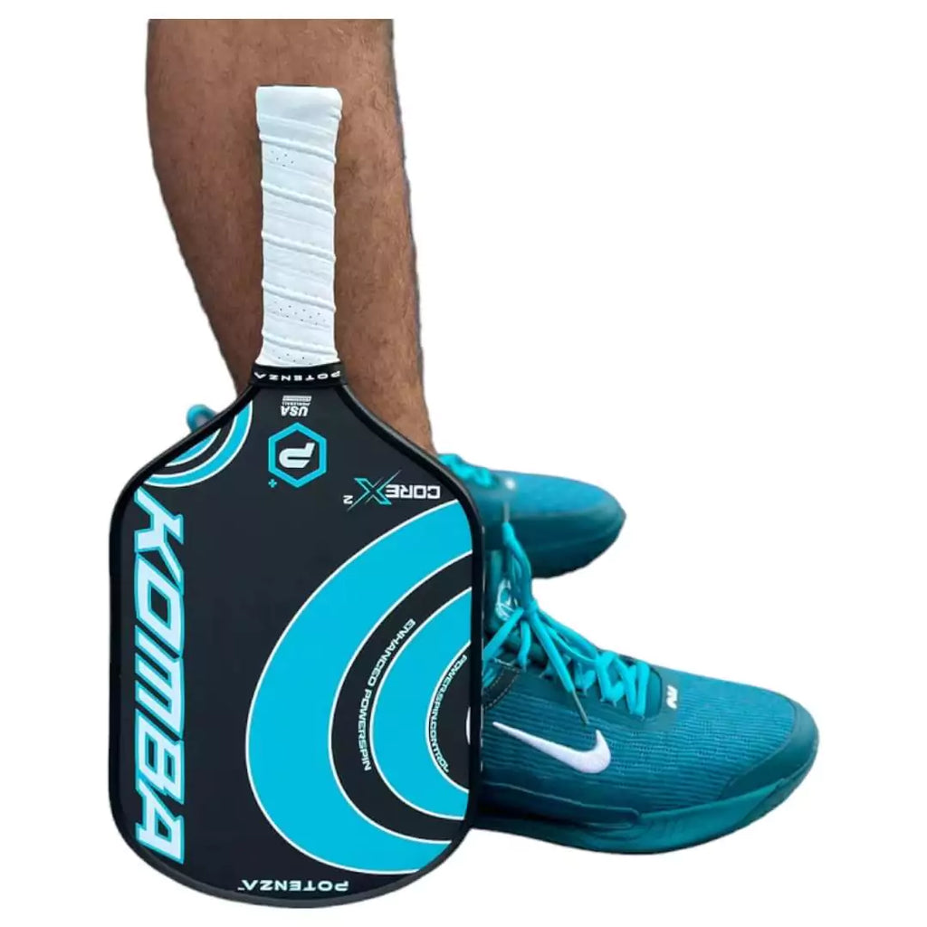 A player standing with a  Potenza KOMBA+CORE*2 Pickleball Paddle, available at iamracketsports.com.