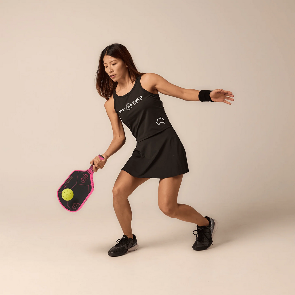 A female player using the Six Zero RUBY PRO 14mm PickleBall Paddle,  available from IamRacketsports.com, online and in-store, Miami USA, worldwide shipping.