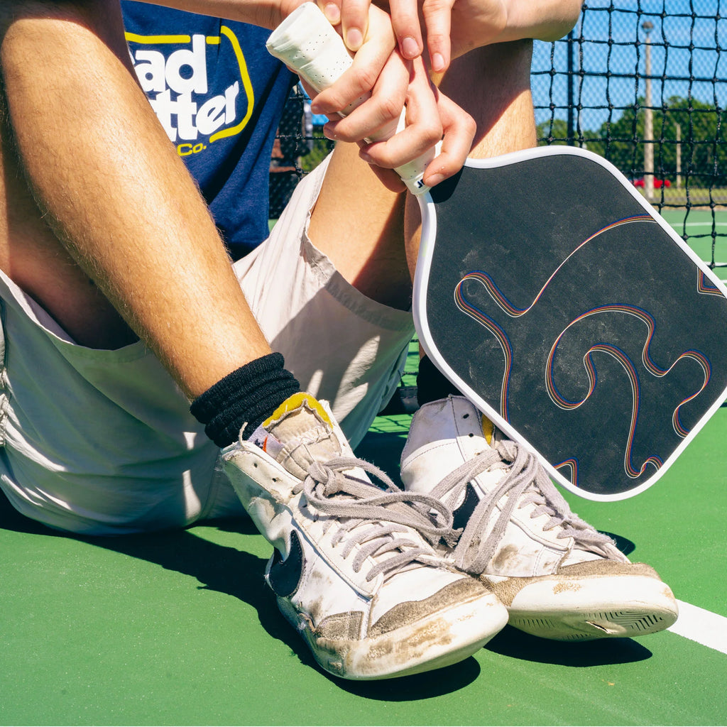 A player on court with a white Bread & Butter Filth 16mm 2024 Elongated Pickleball Paddle, available at iamracketsports.com.