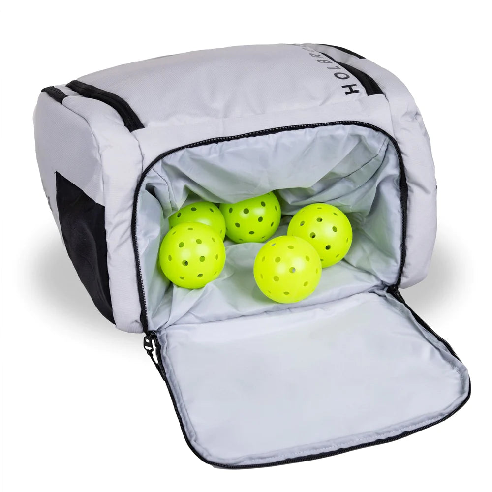 SPORT:PICKLEBALL.   Shop Holbrook Pickleball at "iamPickleball.Store". A Holbrook pickleball Podium paddle/racket rucksack bag in light grey with black zips showing shoe, ball compartment.