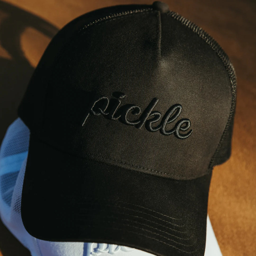 A black Pickle Brand SCRIPT TRUCKER Hat , shop for at iamRacketSports.com.