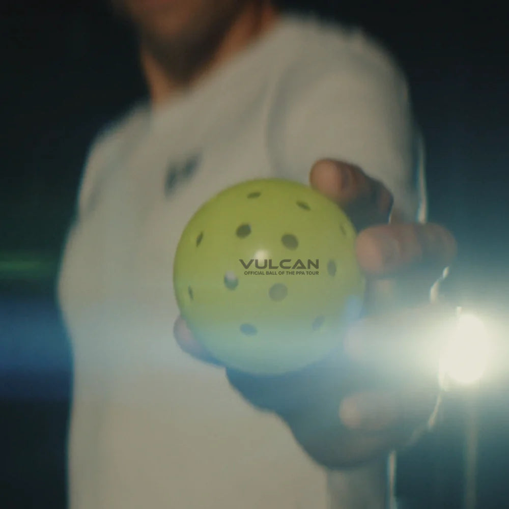SPORT: PICKLEBALL. Find Vulcan Sporting Goods at "iamPickleball.store". A player holding a  Vulcan VPRO FLIGHT Outdoor PPA Tour Pickleball, ball.