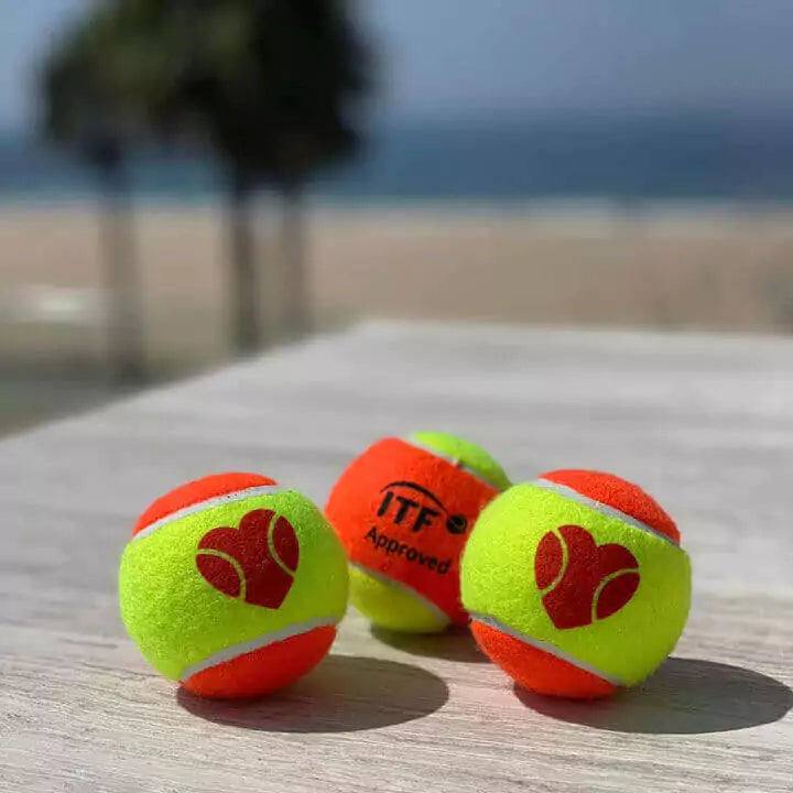 Shop Sexy Brand Beach Tennis at "iambeachtennis" an online store based out of Miami. Sexy "I Love BT" Beach Tennis balls. Image shows 3 balls on the sand.
